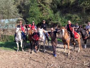 a group of people riding horses on a field at Agriturismo Cascina L'Arché in Santo Stefano Belbo