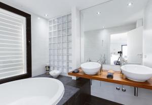 ein Badezimmer mit zwei Waschbecken und einer großen Badewanne in der Unterkunft Can Guasch in Sant Llorenç de Balàfia + 37 Fotos