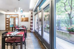 a restaurant with tables and chairs and large windows at Penzion Palouček in Prague