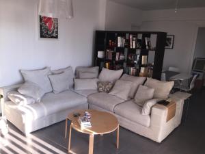 ein Wohnzimmer mit einem Sofa und einem Tisch in der Unterkunft Home away from Home in Paphos City