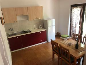 a kitchen with a table and a white refrigerator at Apartmani Eta in Pag