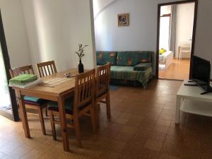 a dining room with a table and chairs and a couch at Apartmani Eta in Pag