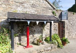 a red pole in front of a building with a roof at Blackwater Eco Pods in Villierstown