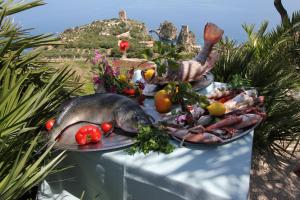 a plate of food with a fish and vegetables at Torre Bennistra in Scopello