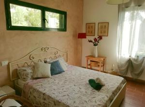 a bedroom with a bed with a green hat on it at La Casetta in Mortola Inferiore