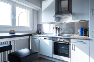 a kitchen with white cabinets and a stove top oven at 2 Bedroom Penthouse in Gasperich in Luxembourg