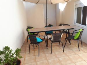 uma mesa e cadeiras com um guarda-sol num quarto em Crisapartment em Lisboa