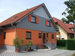een oranje en grijs huis met oranje ramen bij Ferienwohnung Rheintal in Kappel-Grafenhausen