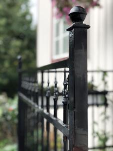 a black iron fence in front of a house at Hotel Palo in Naantali