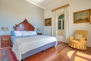 a bedroom with a large bed and a chair at Century House with private pool by HR Madeira in Funchal