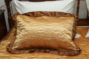 a brown pillow sitting on top of a bed at Apartman ŠOKICA in Bizovac