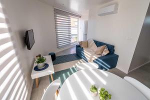 - un salon avec une table, des chaises et une télévision dans l'établissement Apartments Brussels Airport, à Zaventem