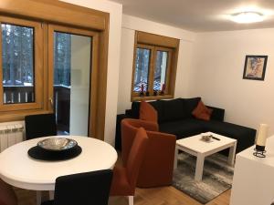 a living room with a couch and a table at Zlatibor apartmani Jakovljevic in Zlatibor