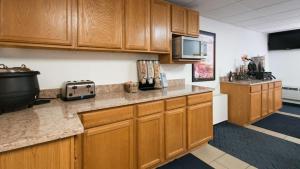 a kitchen with wooden cabinets and a counter top at Best Western Lee's Motor Inn in Chamberlain