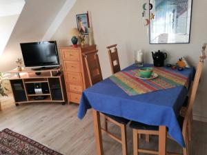 a dining room with a blue table and a tv at 2-Zimmer Ferienwohnung im Zentrum von Binz in Binz