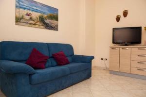 a blue couch in a living room with a tv at Casa Aurelia in Mascali