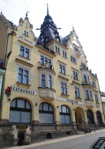 a large yellow building on the side of a street at Hotel Obecní dům in Semily