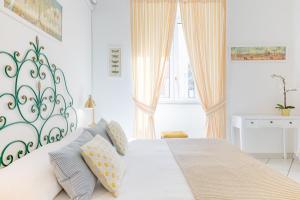 ein weißes Schlafzimmer mit einem großen weißen Bett mit Kissen in der Unterkunft B&B Piazza Fratti in Civitavecchia