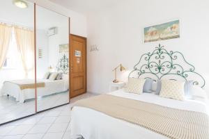 Un dormitorio blanco con dos camas y un espejo. en B&B Piazza Fratti, en Civitavecchia 79 fotos más