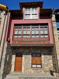 ニエンブロにあるCasa Guela Niembroの木製のドアと窓のある赤い建物