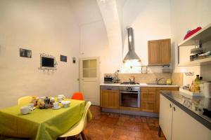 une cuisine avec une table et un tissu de table vert dans l'établissement Stilmoderno Nice Apartment in Siena's Historic Center, Just Steps from Piazza del Campo, à Sienne