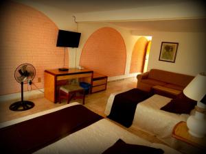 a living room with a couch and a desk at Hotel Piedras de Sol Solaris Morelos in Tlaltizapán