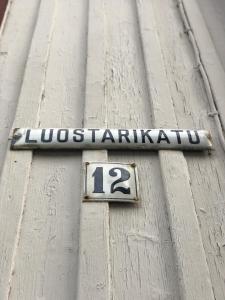 a sign on the side of a building with the number at Hotel Palo in Naantali