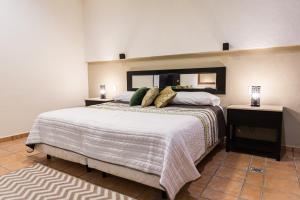 Un dormitorio con una cama grande y un espejo. en Departamento familiar, en Playa del Carmen