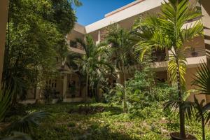Un edificio con palmeras delante. en Departamento familiar, en Playa del Carmen