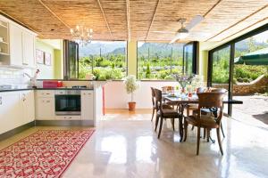 Heuwelsig Cottages في فرانستشوك: مطبخ وغرفة طعام مع طاولة وكراسي