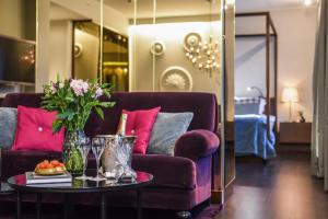 a living room with a purple couch and a table with flowers at Elite Eden Park Hotel in Stockholm