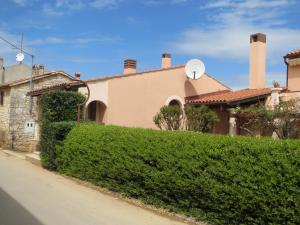 a house with a hedge in front of a street at Apartments Mediteraneo in Tar