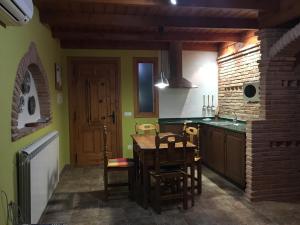 a kitchen with a wooden table and a dining room at El Mirador in Quinto
