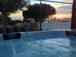 a hot tub with a sunset in the background at L'ESCALE COTE BLEUE B&B AND Spa in Sausset-les-Pins