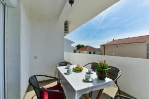 a white table and chairs on a balcony at Apartments Citrus in Turanj