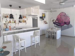 a kitchen with a counter and chairs in a room at Terraza Art Villa Dominicana in Punta Cana