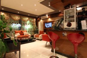 a living room with red chairs and a couch at Taleen AlSulaimanyah hotel apartments in Riyadh