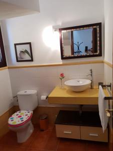 a bathroom with a sink and a toilet and a mirror at Villa La Reina in Cho