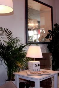 a table with a lamp on it in a living room at Logis Hôtel La Chaize in Noirmoutier-en-l'lle