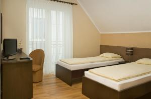 Habitación de hotel con 2 camas y TV en Sand Residence - Pokoje i Apartamenty, en Władysławowo