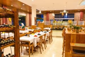 a restaurant with white tables and chairs and a bar at Rodoserv Hotel in Pardinho +58 photos