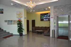 a lobby of a hospital with a couch and a chandelier at Riverview Hotel in Bahau