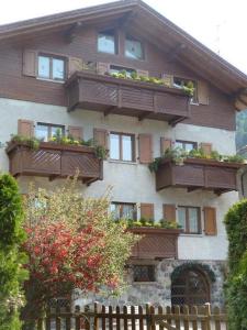 a building with balconies and plants on it at B&B Sotto Al Bosco in Spiazzo