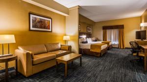a hotel room with a bed and a couch at Best Western Plus Winnipeg West in Winnipeg