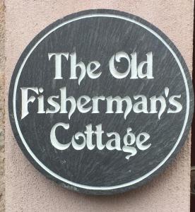 a sign on a wall that reads the old fishermen cottage at Old Fisherman's Cottage in Rothesay