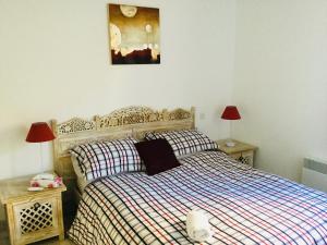 um quarto com uma cama e duas mesas de cabeceira e dois candeeiros em Chez Tranquille, Apartment 43 em Montblanc