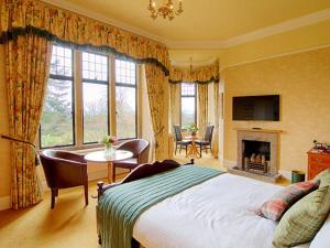 a bedroom with a bed and a table and a fireplace at Kincraig Castle Hotel in Invergordon