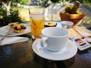 einen Tisch mit einer Tasse Tee und einem Glas Orangensaft in der Unterkunft La Residenza del Marchesato in Marano Marchesato