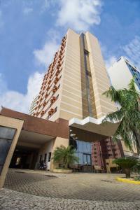 un edificio alto con palme di fronte di Soft Win Hotel São Luís a São Luís