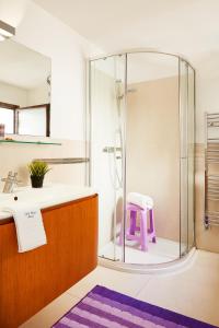 bagno con doccia, lavandino e sgabello viola di Aura CaseSicule, only for Sea View Lovers, Modern Style Apartment in City Center, Wi-Fi a Pozzallo